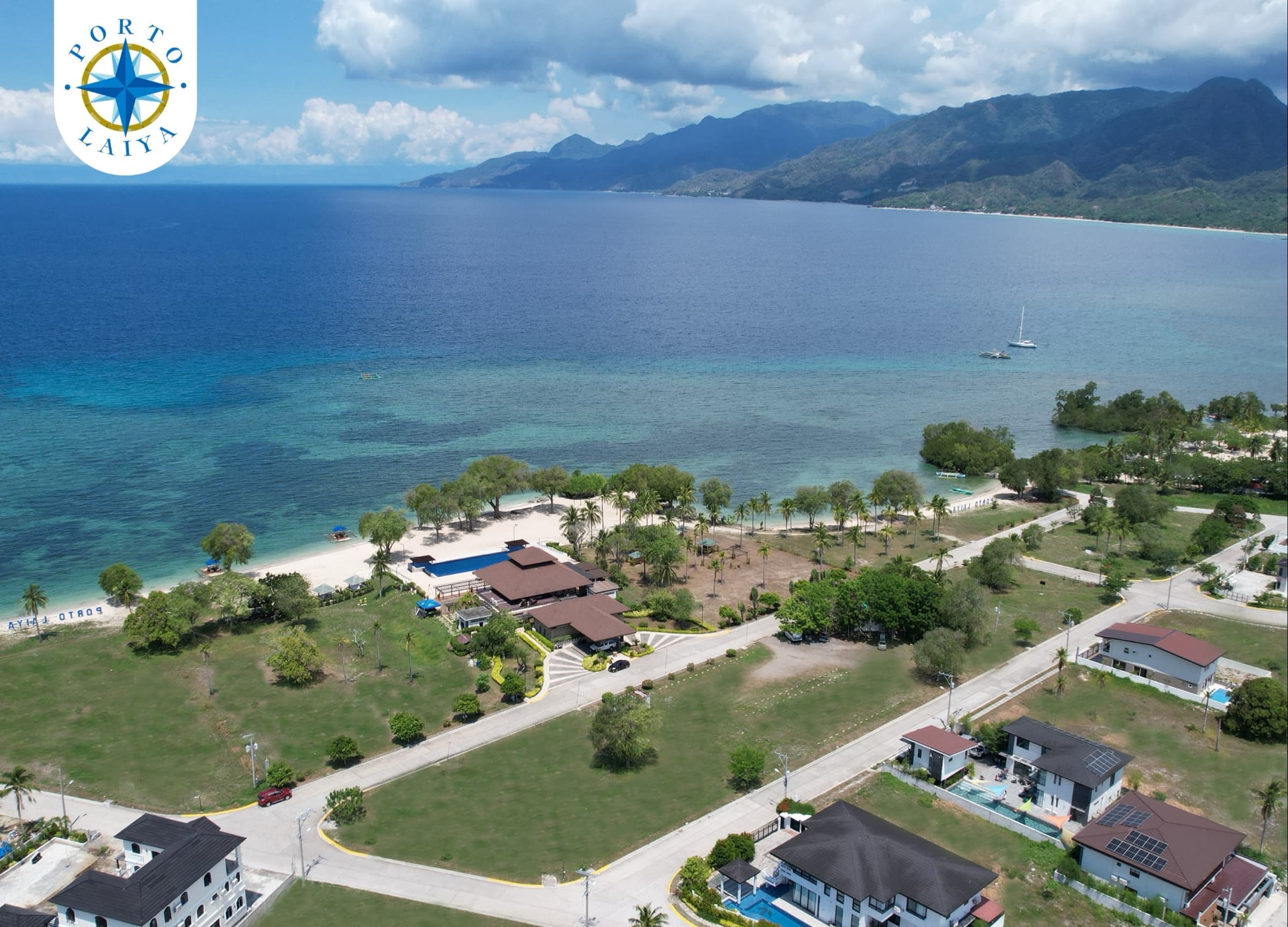 Porto Laiya beach houses and paved roads beside the bay (photo)