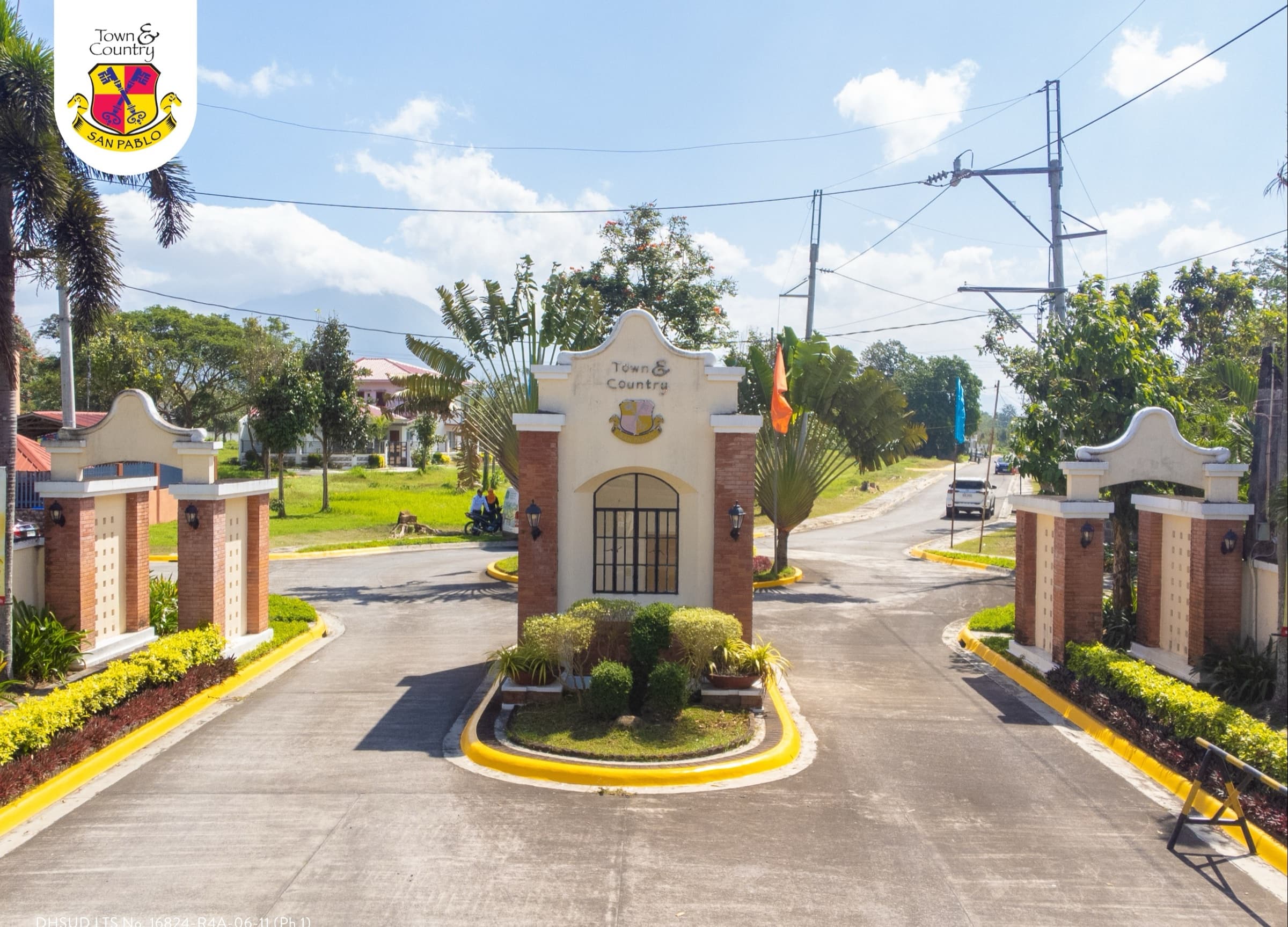 Entrance road through the twin gate pillars, with a landscaped island
